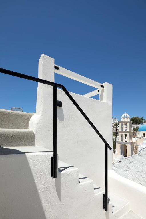 a set of stairs with a blue sky in the background at Acave Santorini Suites in Vóthon