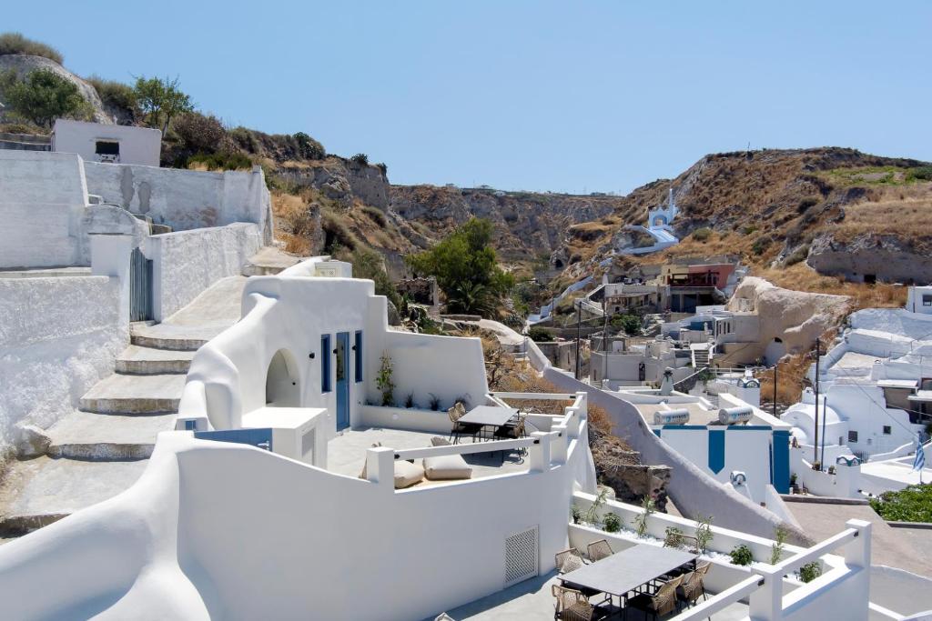 a view of the white buildings on a hill at Acave Santorini Suites in Vóthon