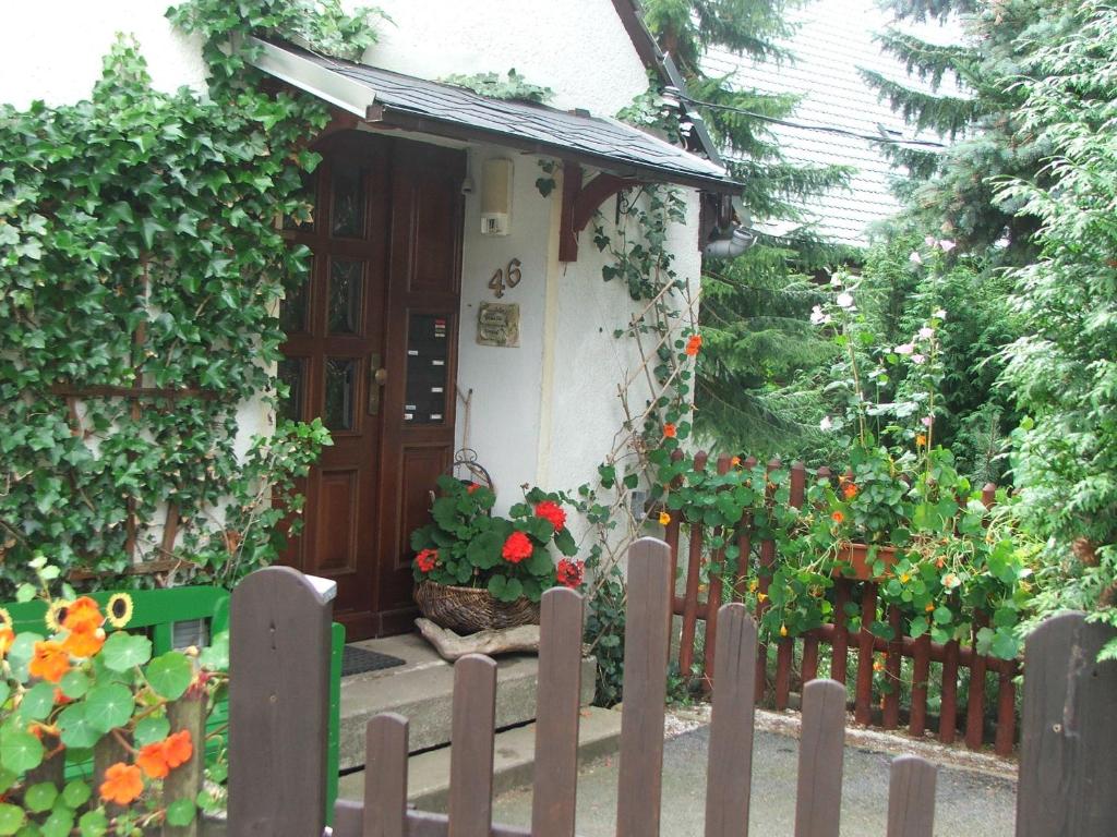 una valla de madera frente a una casa con flores en Ferienwohnung Grenzblick, en Kurort Oberwiesenthal