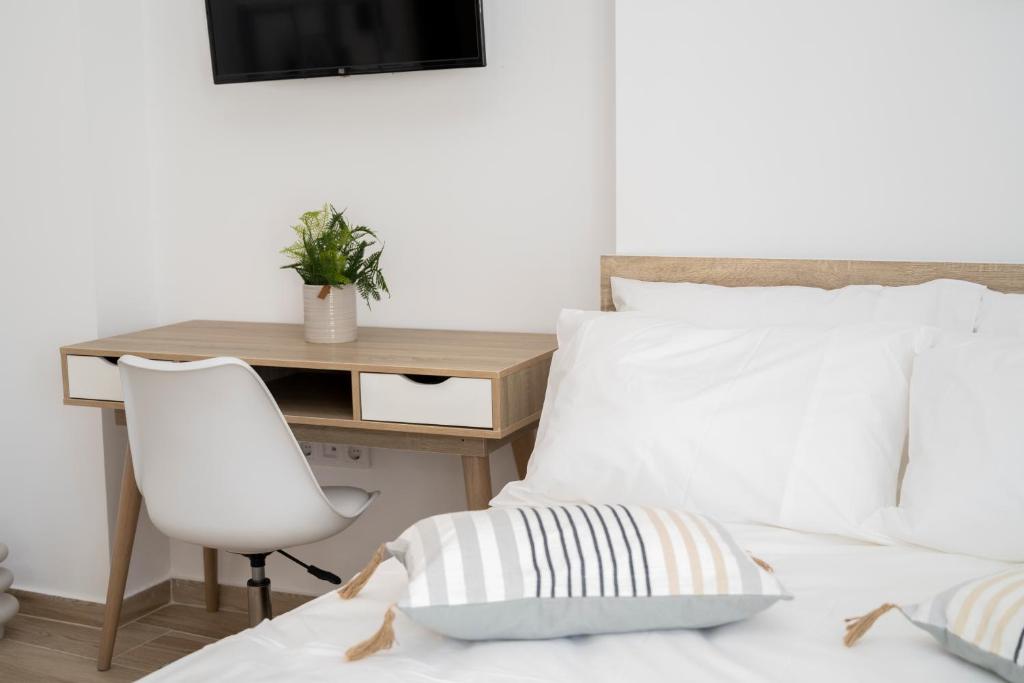 una camera da letto con scrivania e letto con sedia di "Calm Joy & J" - Infinity a Ermoupoli