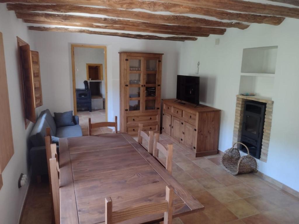 sala de estar con mesa de madera y chimenea en Casa Purujosa, en Purujosa