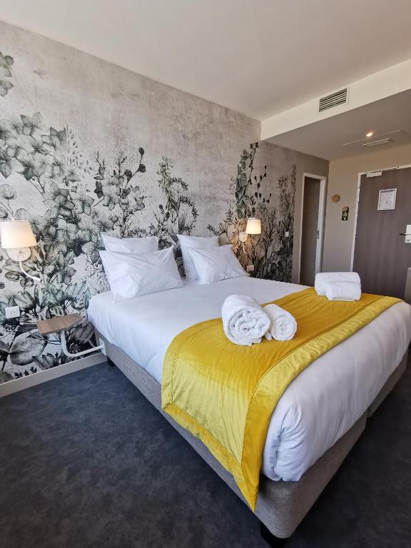 a bedroom with a large bed with towels on it at Aux Ateliers in Miserey-Salines