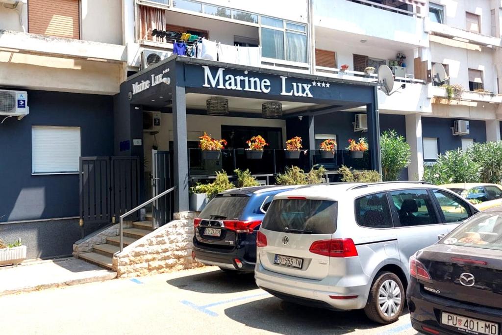 zwei Autos, die vor einer Martinez-Linie geparkt sind in der Unterkunft Marine Lux apartments in Pula