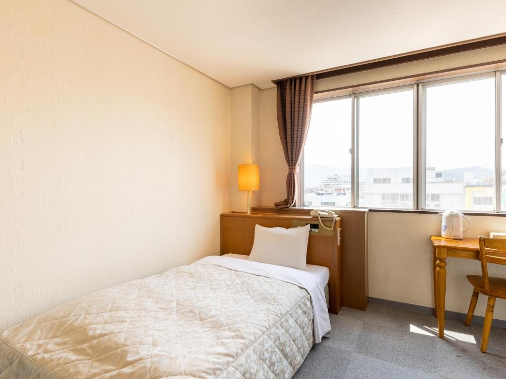 Postel nebo postele na pokoji v ubytování Tabist Kanko Business Hotel Matsuyama Hida Takayama