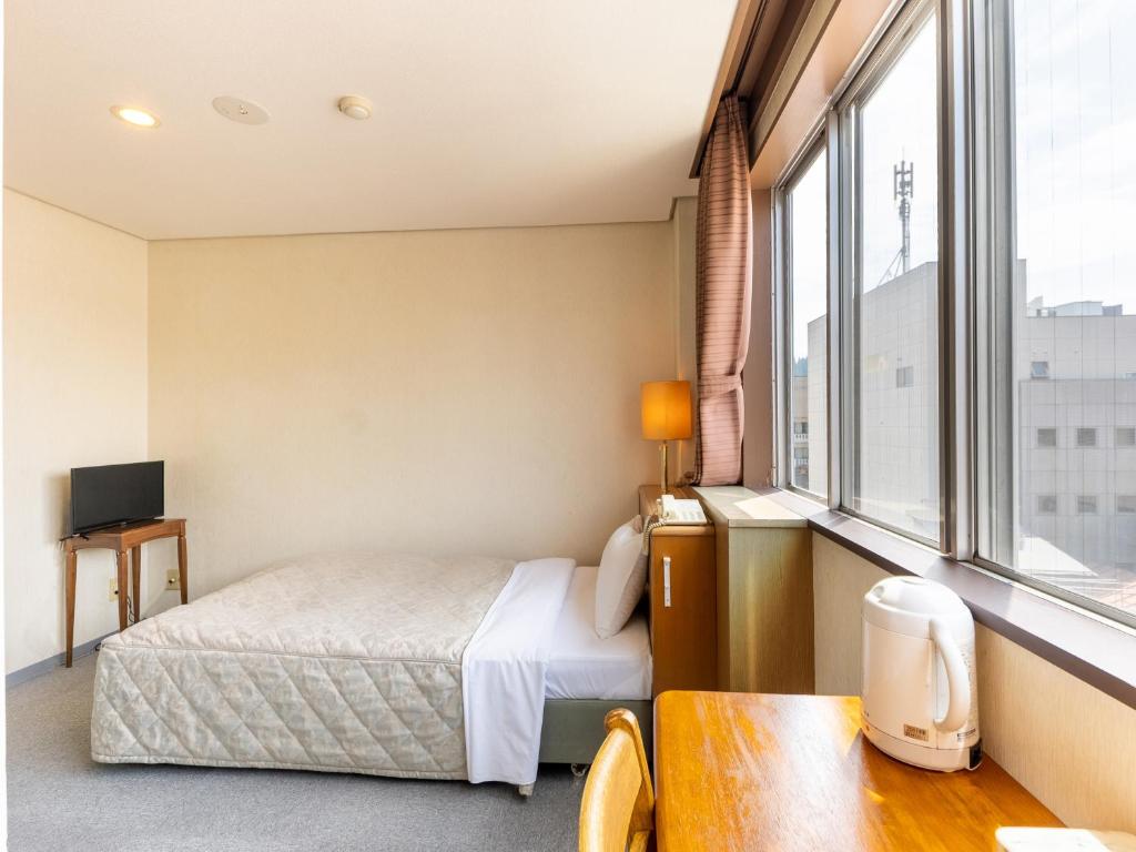 Postel nebo postele na pokoji v ubytování Tabist Kanko Business Hotel Matsuyama Hida Takayama