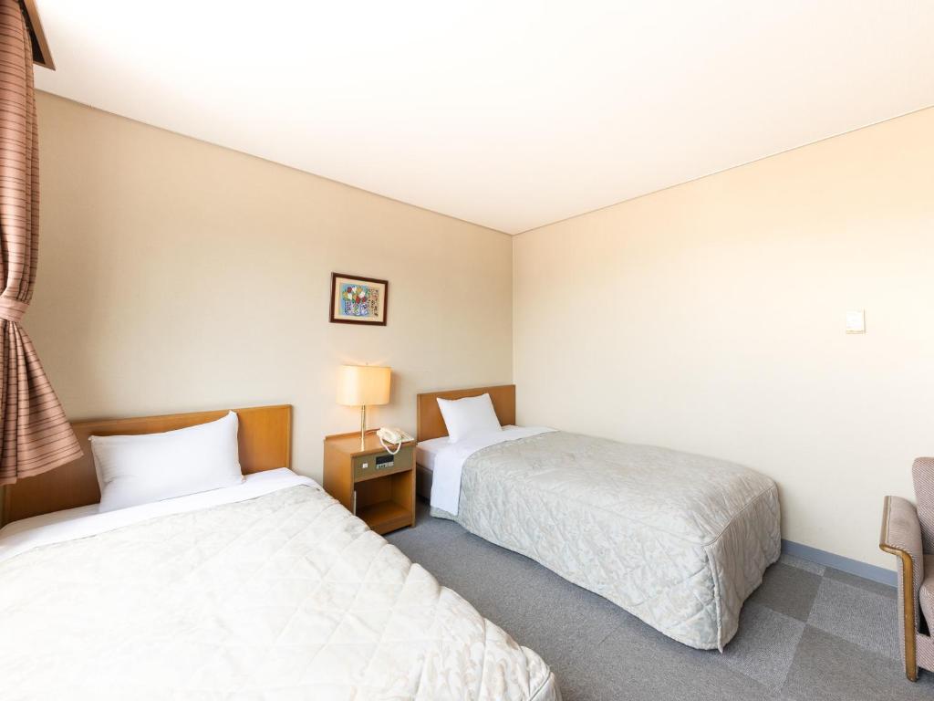 Postel nebo postele na pokoji v ubytování Tabist Kanko Business Hotel Matsuyama Hida Takayama