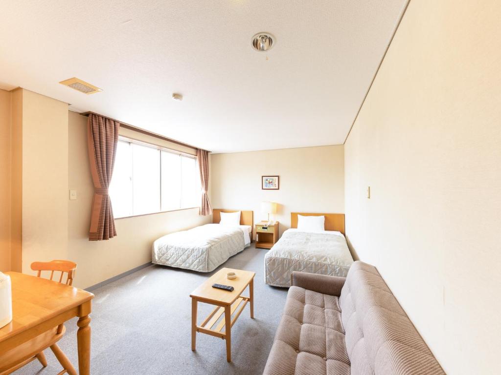 Postel nebo postele na pokoji v ubytování Tabist Kanko Business Hotel Matsuyama Hida Takayama