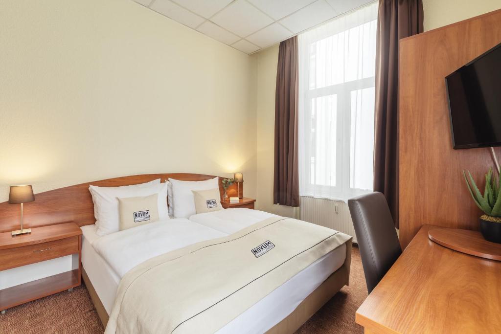 une chambre d'hôtel avec un lit et une télévision dans l'établissement Novum Hotel Hamburg Stadtzentrum, à Hambourg