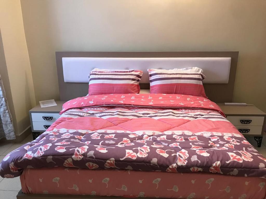 a bed with two pillows on top of it at Maliaways Comfy Airbnb-Jkia in Nairobi