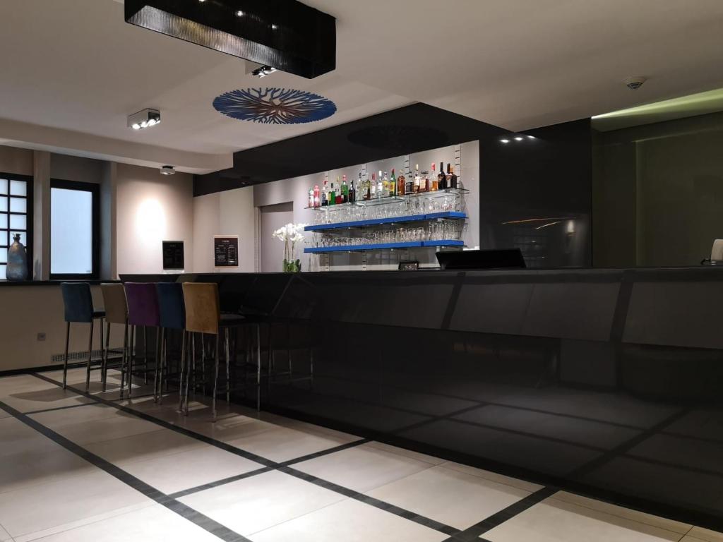 eine Bar in einem Restaurant mit Barhockern in der Unterkunft Hotel Floris Arlequin Grand-Place in Brüssel