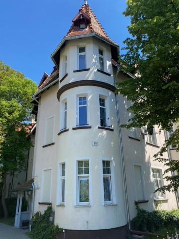 um edifício branco com uma torre de relógio em cima em Apartament Władysława IV em Sopot