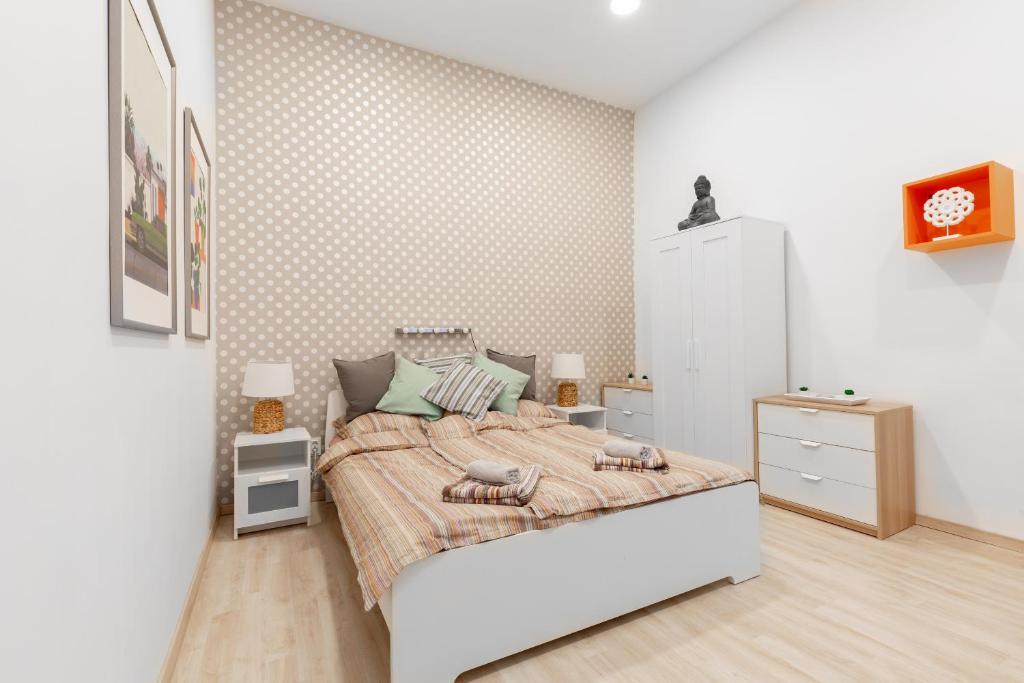 Dormitorio blanco con cama y pared en Apartment Colourful, en Budapest