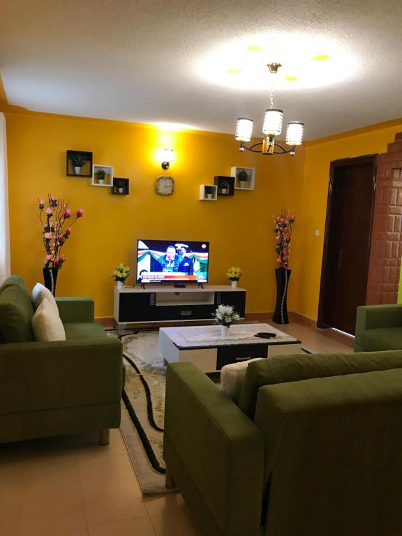 a living room with two couches and a tv at Maliaways Comfy Airbnb-Jkia in Nairobi