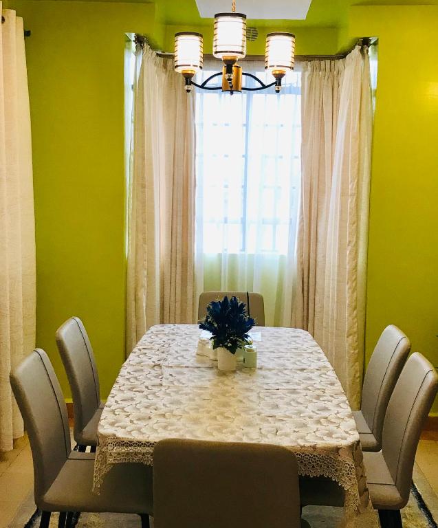 a dining room with a table with chairs and a window at Maliaways Comfy Airbnb-Jkia in Nairobi