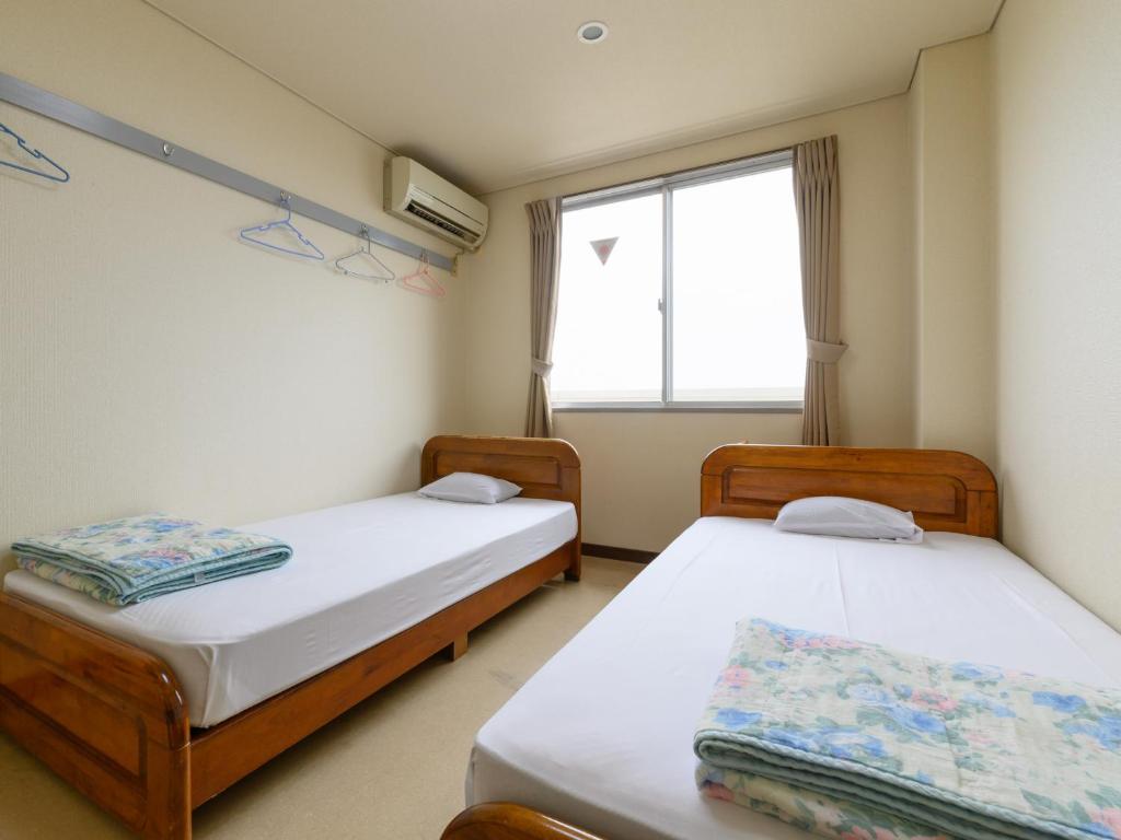 Postel nebo postele na pokoji v ubytování Tabist Business Hotel Kaigansou Gamagori