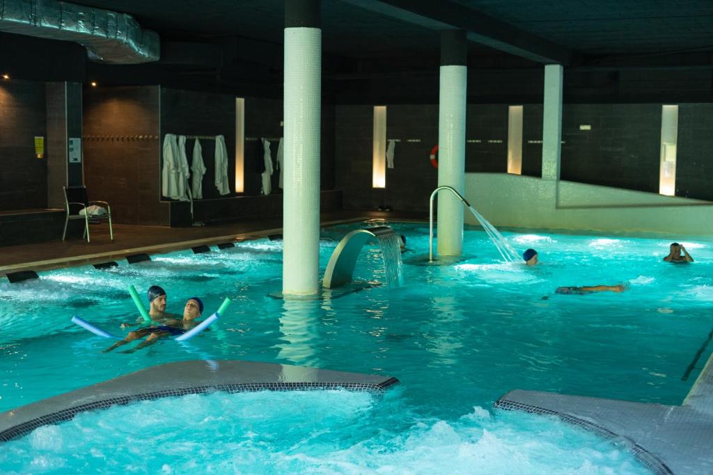 eine Gruppe von Personen, die in einem Schwimmbad schwimmen in der Unterkunft Hotel Real Balneario Carlos III in Trillo