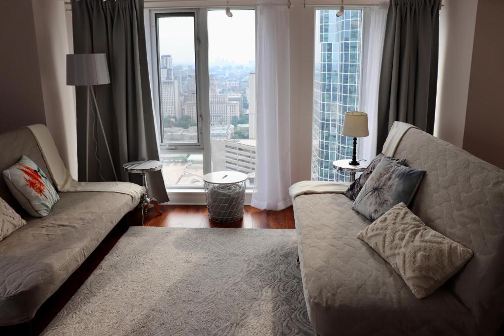 - un salon avec un canapé et une grande fenêtre dans l'établissement Apartment/2Bedrooms/2 Full Bathrooms/Free parking, à Toronto