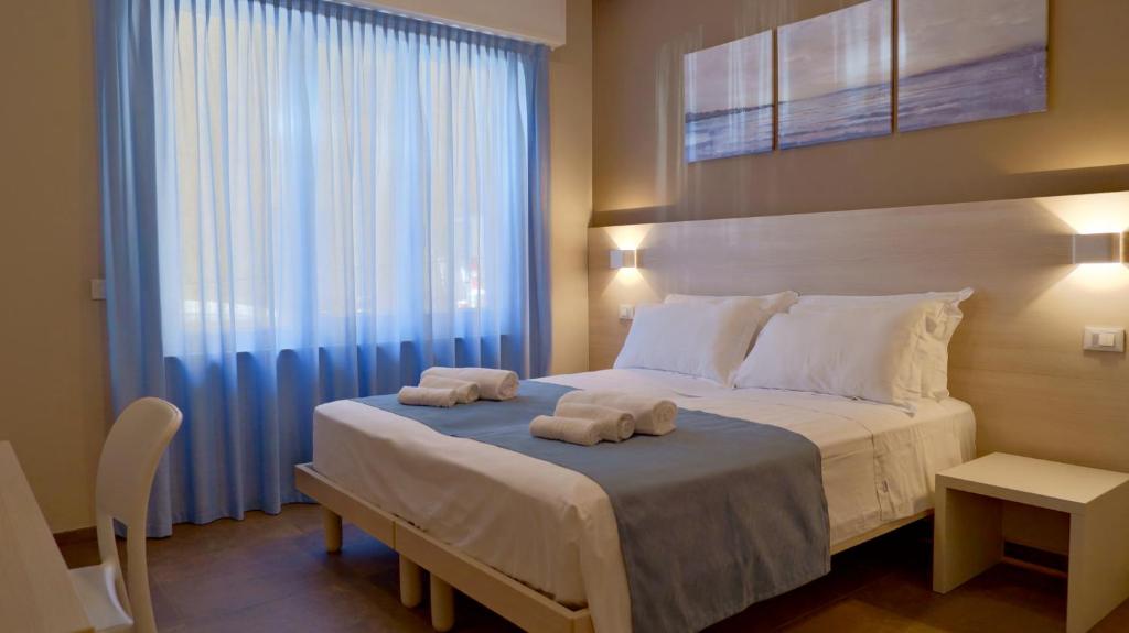 a bedroom with a large bed with towels on it at Pianomare Riviera Apartments and Rooms in Imperia