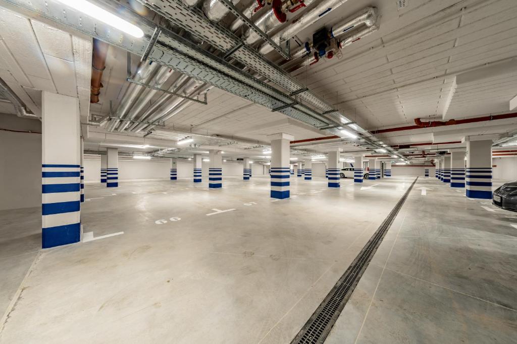 un parking vide avec des colonnes bleues et blanches dans l'établissement Rezydencja Niechorze 108 Prestige by The Beach z Basenem i SPA, à Niechorze