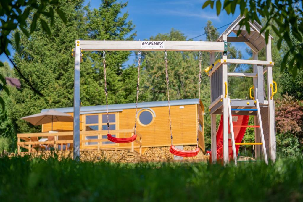 a playground with a slide and a play structure at Maringotky Na Růžku in Nová Ves