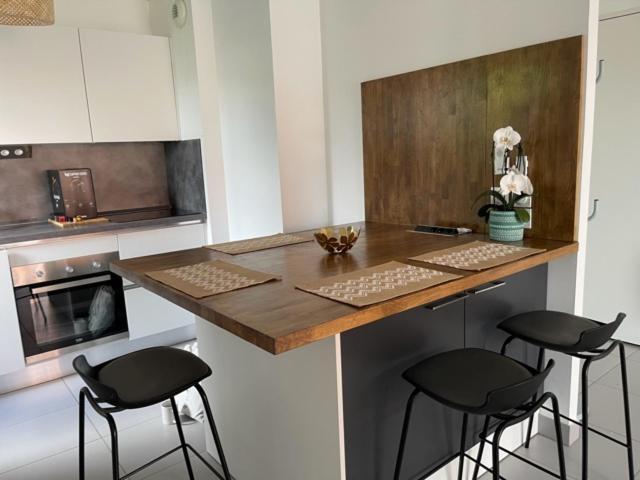 une cuisine avec comptoir et tabourets dans l'établissement RIVIERA COTTAGE, à Mandelieu-la-Napoule