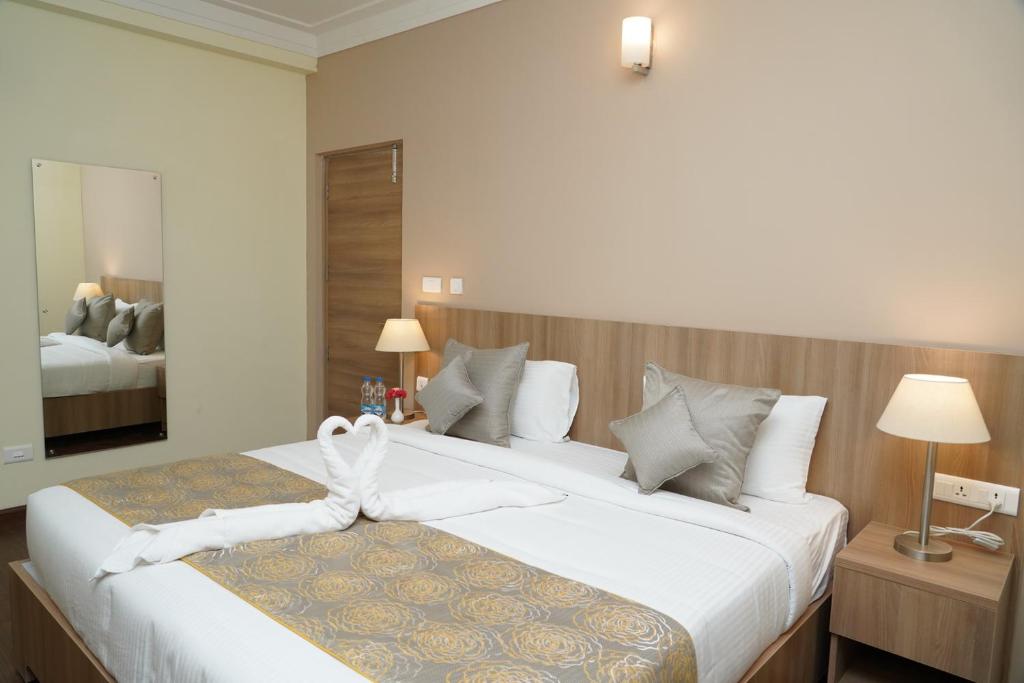 Postel nebo postele na pokoji v ubytování Starlit Suites Tirupati