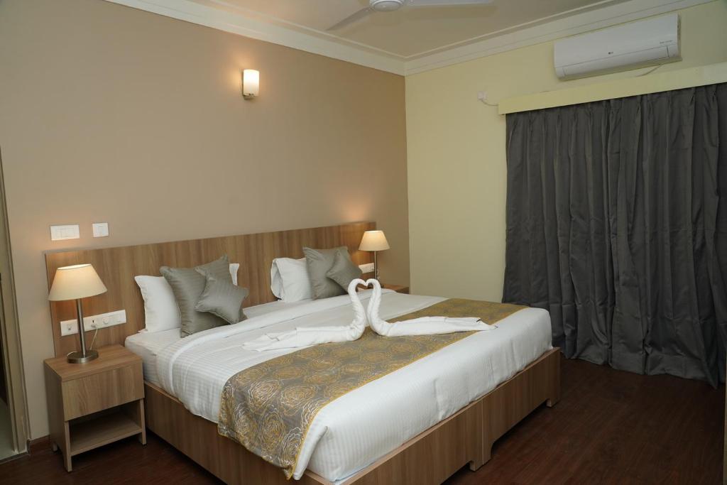 Postel nebo postele na pokoji v ubytování Starlit Suites Tirupati