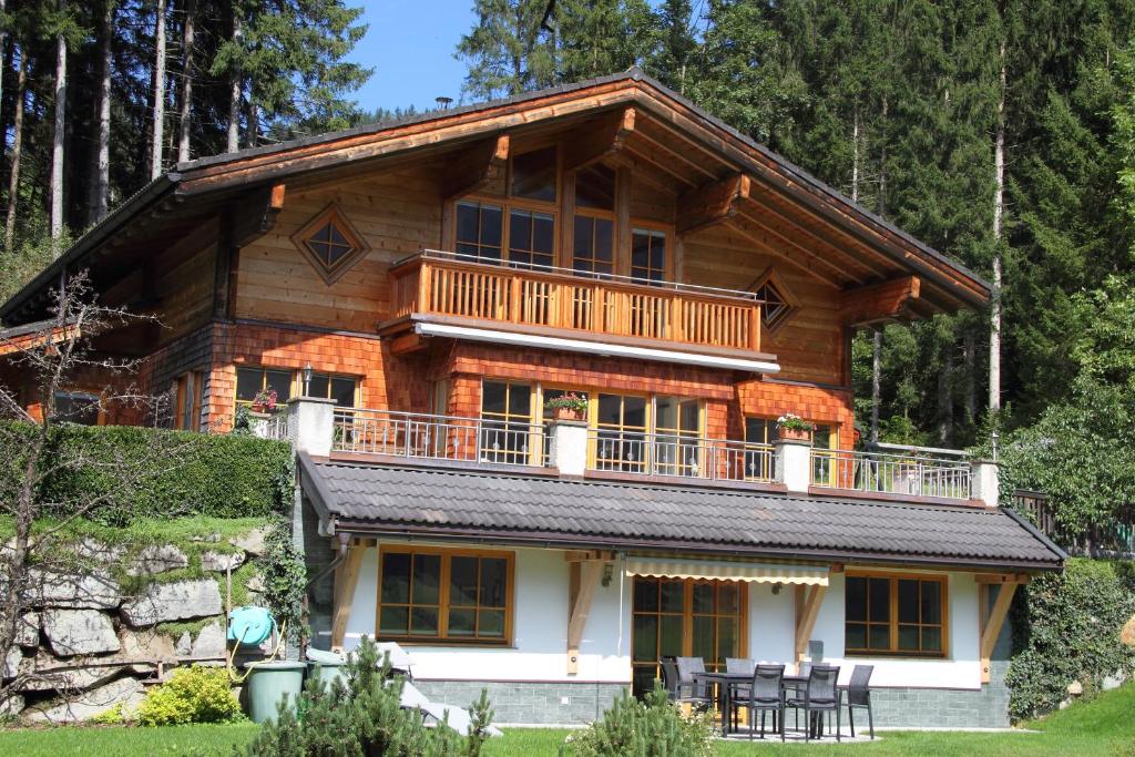 ein großes Blockhaus mit Balkon darüber in der Unterkunft Am Waldrand in Mittersill