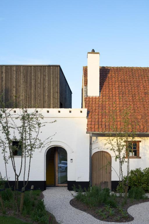 a white building with a red roof at HUIS19 Luxury apartments in Ghent