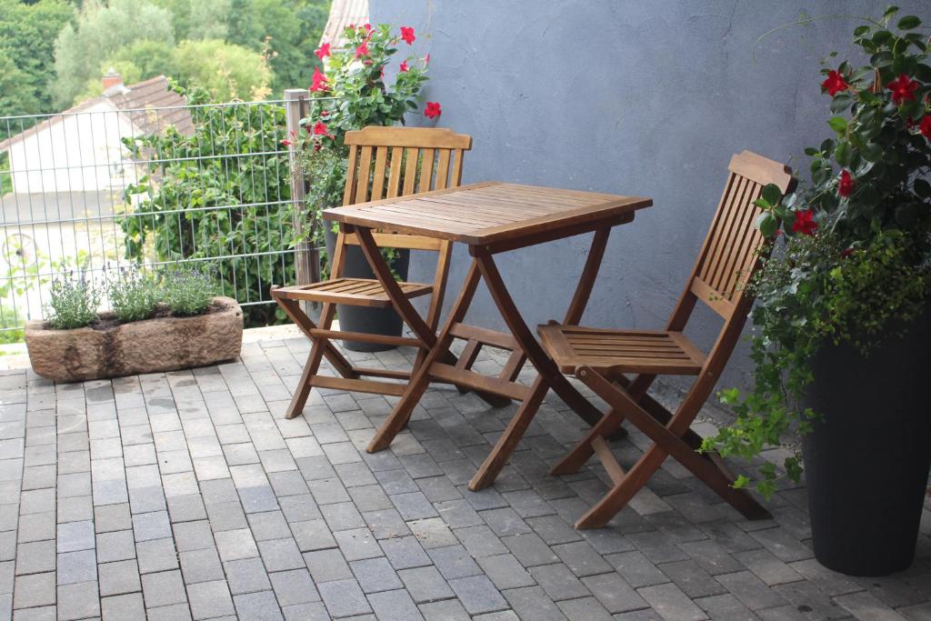 a wooden table and two chairs on a patio at Ferienwohnung Felgenwald in Michelstadt