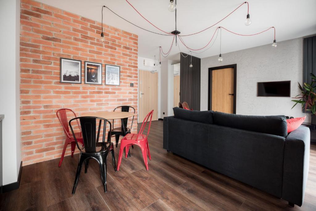 uma sala de estar com um sofá, uma mesa e cadeiras em Loft em Szczecin