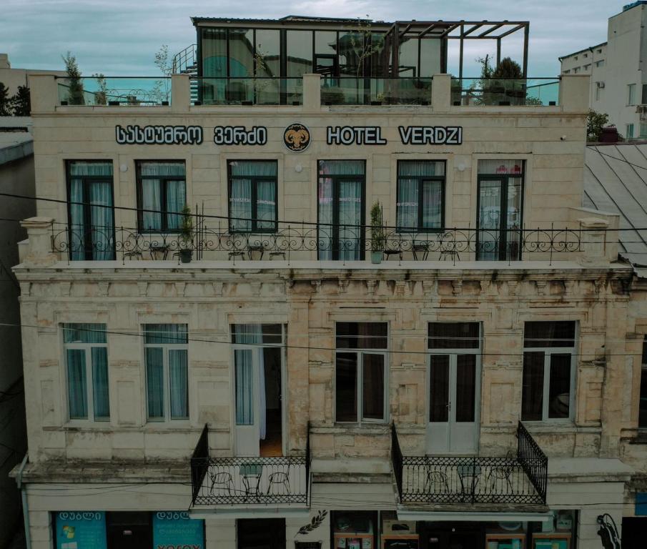 um edifício antigo com um hotel em cima em Hotel Verdzi em Kutaisi