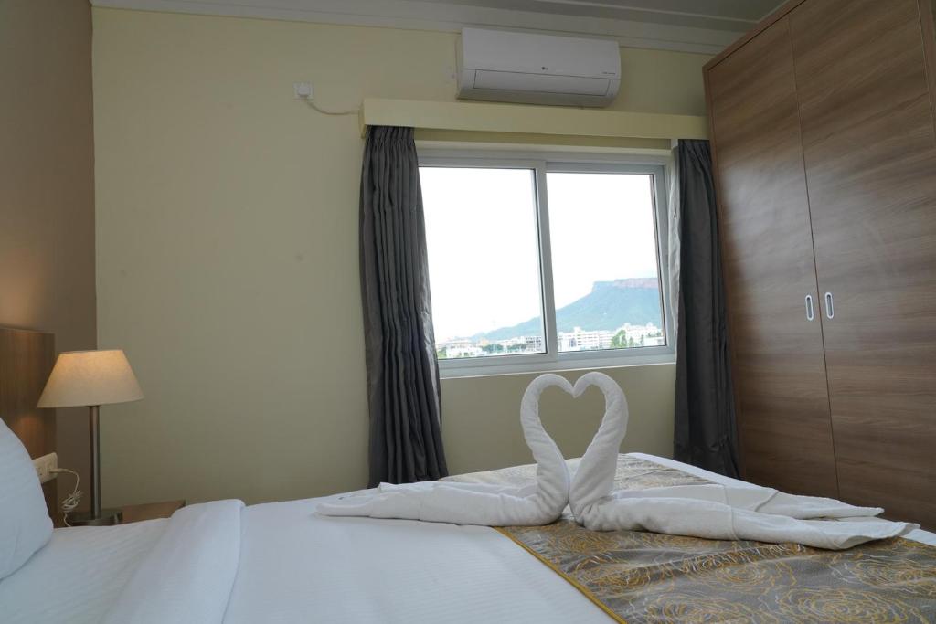 Postel nebo postele na pokoji v ubytování Starlit Suites Tirupati