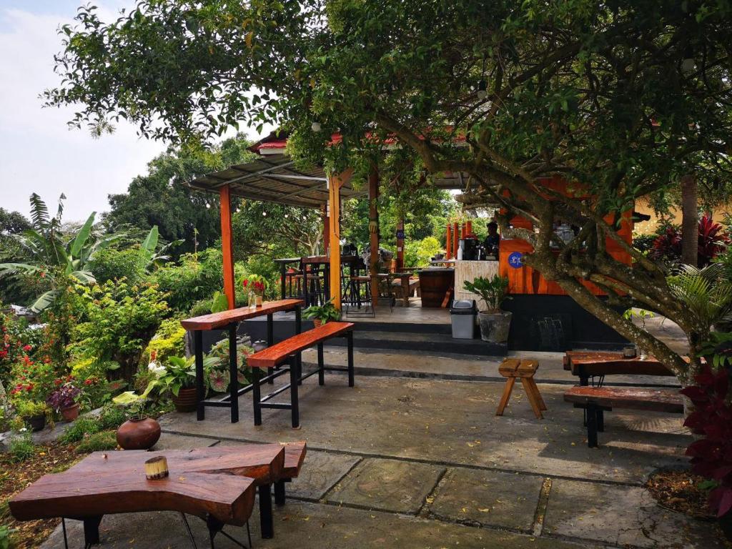 Balelangga Bed & Breakfast في Sapit: مجموعة طاولات وكراسي في حديقة