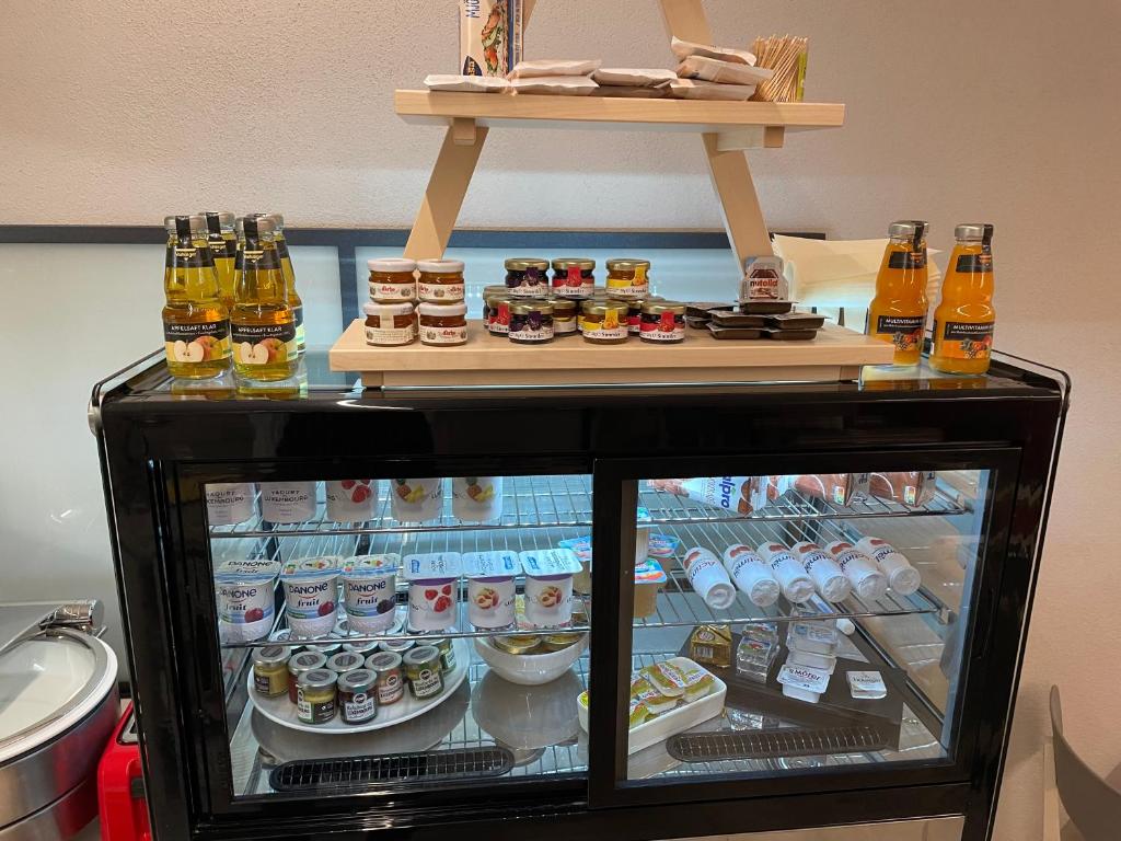 a refrigerator filled with food and drinks on a shelf at Hotel Monvillage in Mondercange