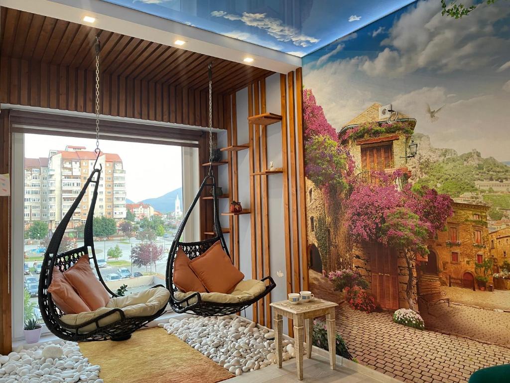 a room with a hanging hammock in front of a mural at Happy Time 1 in Petroşani