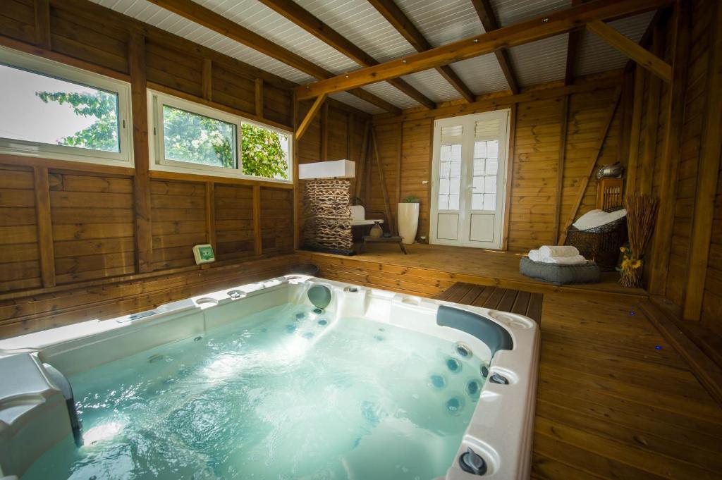 a large bath tub in a room with wooden walls at Locastudio - Pomme Kanel in Sainte-Anne