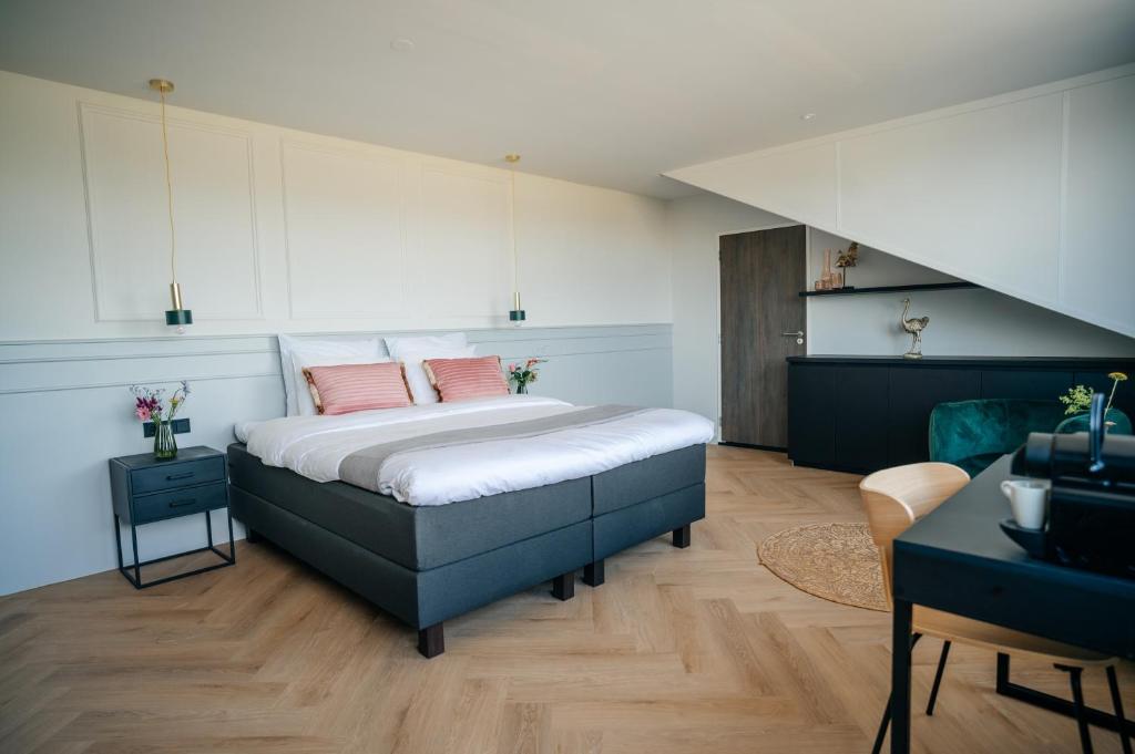 Un dormitorio con una cama con almohadas rosas. en MyHotel Steenwijk - Giethoorn en Steenwijk