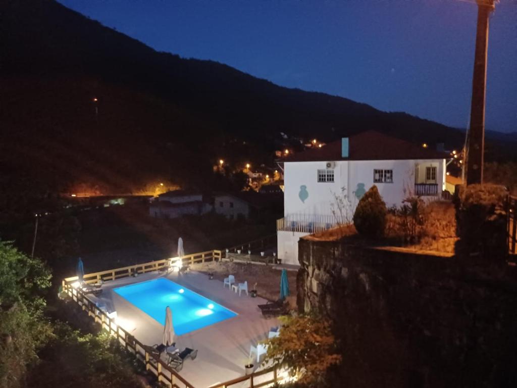 a view of a swimming pool at night at Waterfalls Gerês AL in Geres