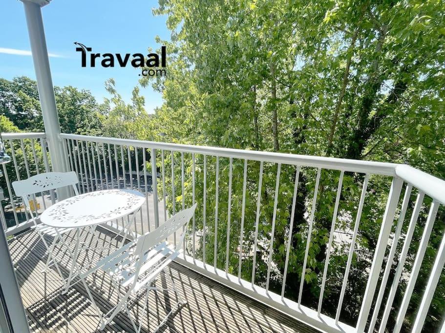 a balcony with a table and chairs on a white railing at Travaal - 2 Bed Serviced Apartment Farnborough in Farnborough