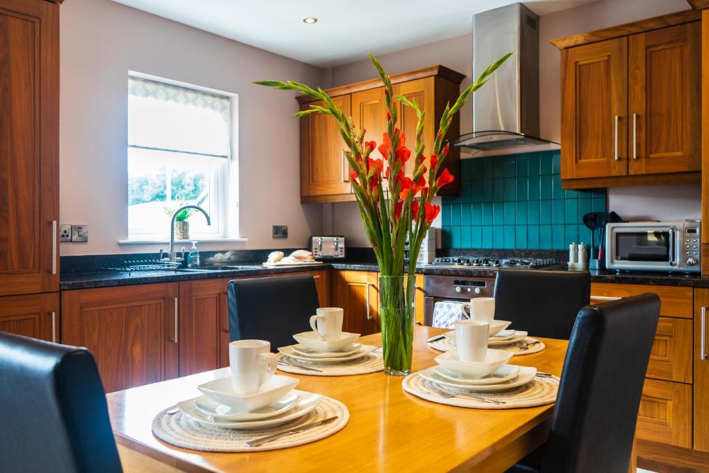 a kitchen with a wooden table with a vase of flowers at The Arches in Ballycastle