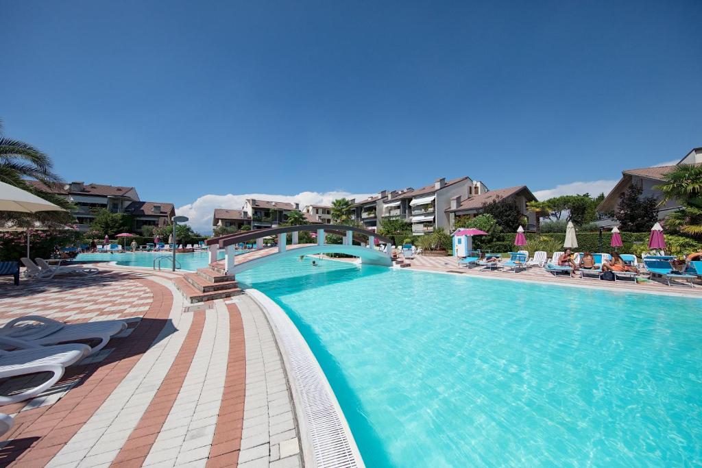 uma grande piscina com cadeiras e guarda-sóis em Mandorli 1-18 by Wonderful Italy em Desenzano del Garda