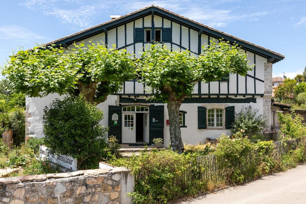 une maison blanche et noire avec des arbres devant elle dans l'établissement Domaine de Bassilour, à Bidart