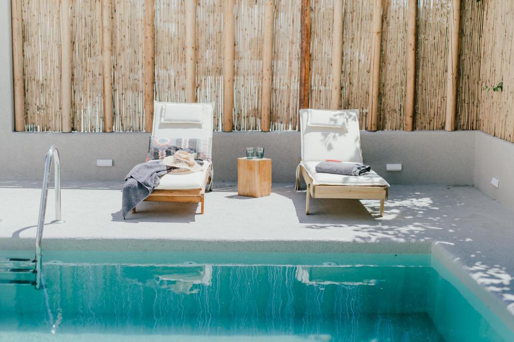 a room with two chairs and a swimming pool at Kostantakis Pool house in Pollonia