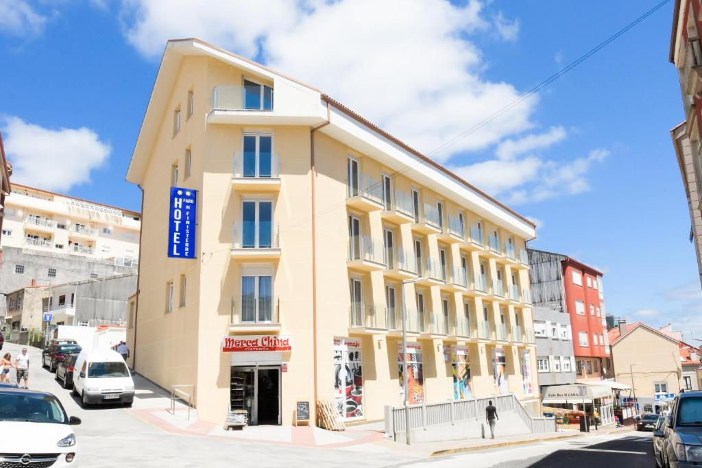 a large yellow building on a city street at Hotel Faro de Finisterre in Finisterre