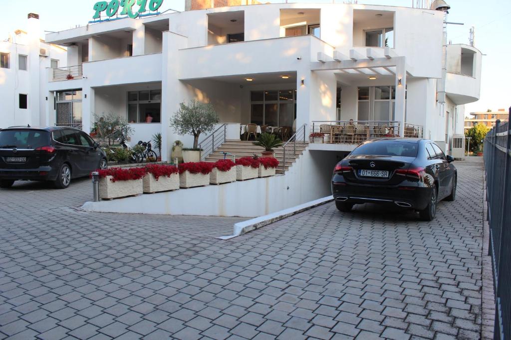 two cars parked in front of a building at Hotel Porto A in Ulcinj