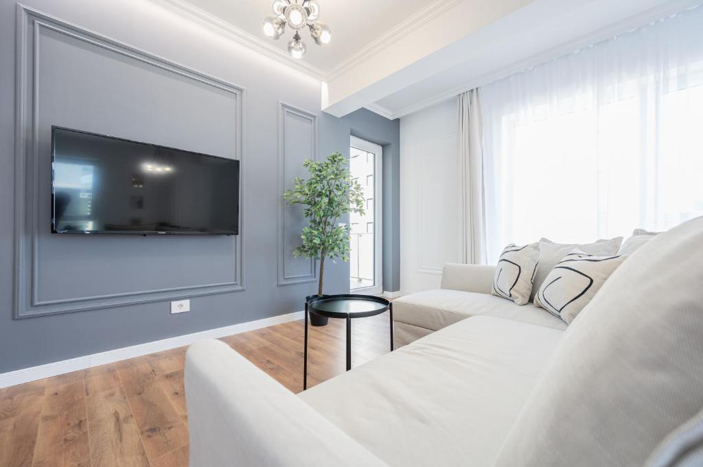un soggiorno bianco con divano bianco e TV di Brioni Flat a Oradea