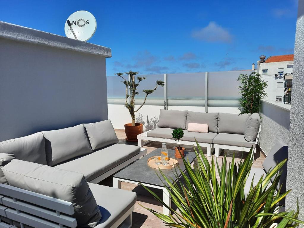 a patio with couches and a table on a balcony at Sitius 5B - NEW seaview apartment with rooftop terrace in historical centre Sitio da Nazaré in Nazaré