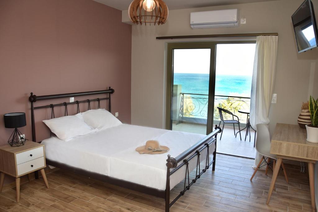 a bedroom with a bed and a balcony with the ocean at Αιγιαλίς - Πολυτελη διαμερισματα in Karistos