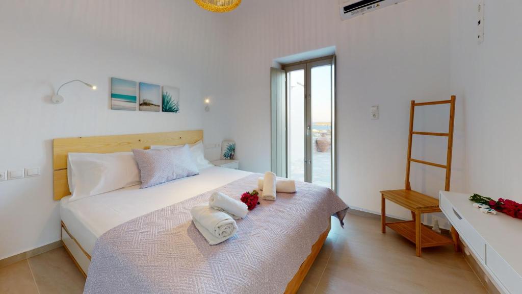 1 dormitorio con 1 cama con toallas en ONAR RESIDENCE PAROS, en Chrissi Akti